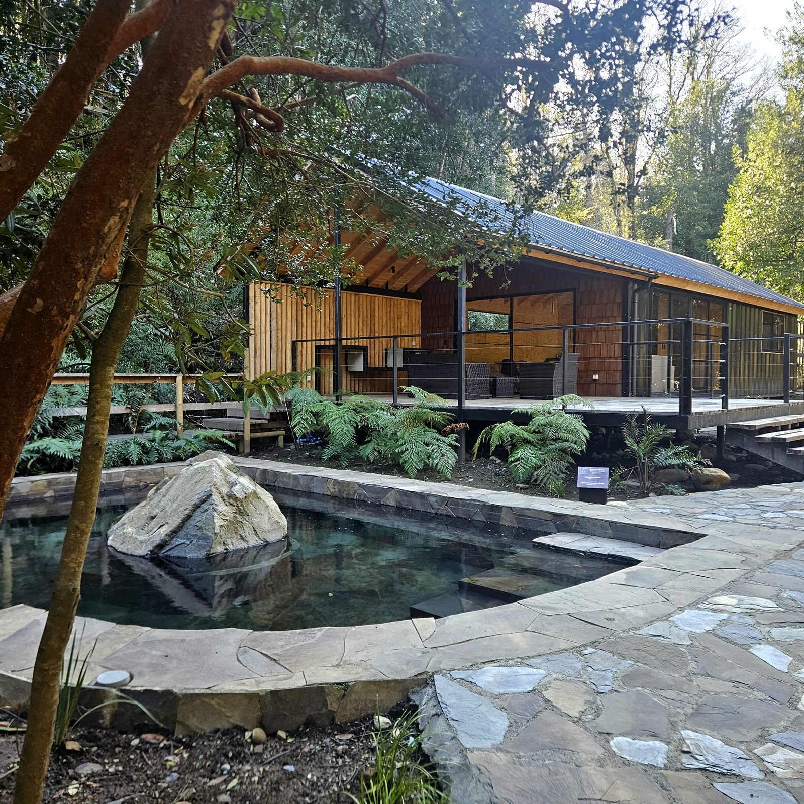 Clubhouse de madera del condominio junto a la piscina termal